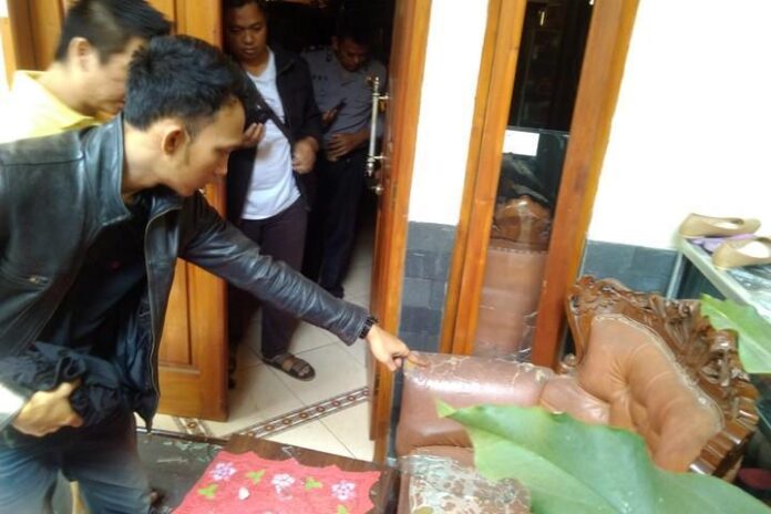 Warga menunjukkan pecahan kaca dari rumah miliknya yang terdampak karena ledakan gudang senjata Mako Brimob.