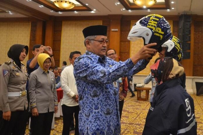 Sekda Jateng Sri Puryono memberikan helm kepada peserta pelatihan safety riding yang diadakan BPJS Ketenagakerjaan Jateng-DIY, Selasa (17/9).