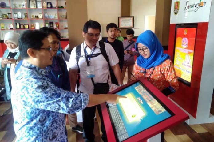 Kabid Pengelolaan Informasi dan Saluran Komunikasi Publik Diskominfo Kota Semarang Sucahyo Kuswirantomo (kiri) menjelaskan soal buku tamu berbasis digital yang wajib diisi warga saat datang ke Pusat Informasi Publik, kemarin.
