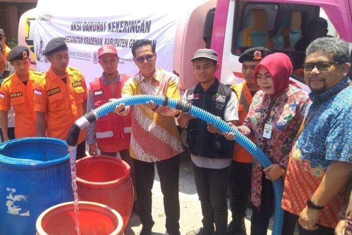 Kepala KPw BI Jateng Soekowardojo secara simbolik mendistribusikan air bersih kepada warga di Kecamatan Kradenan, Grobogan, Selasa (24/9).