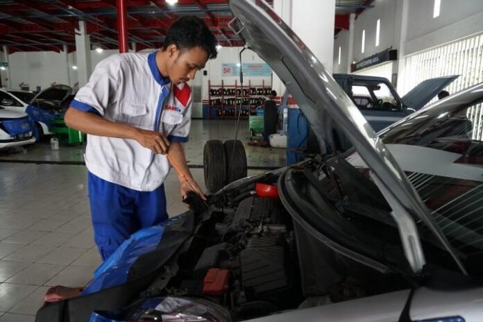 Seorang mekanik di CARfix sedang melakukan perawatan berkala terhadap mobil pelanggan.