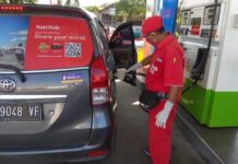 Operator SPBU sedang melayani pelanggan