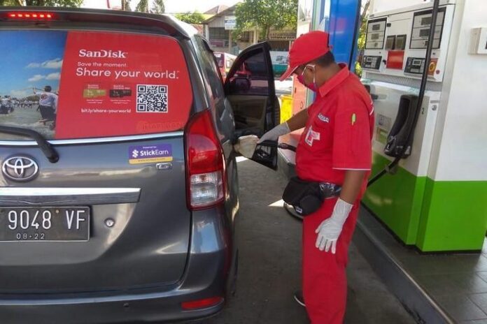 Operator SPBU sedang melayani pelanggan