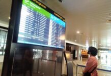 Seorang calon penumpang melihat jadwal penerbangan di Bandara Internasional Jenderal Ahmad Yani Semarang.