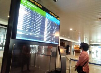 Seorang calon penumpang melihat jadwal penerbangan di Bandara Internasional Jenderal Ahmad Yani Semarang.