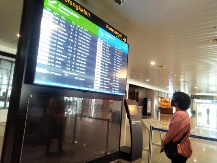 Seorang calon penumpang melihat jadwal penerbangan di Bandara Internasional Jenderal Ahmad Yani Semarang.