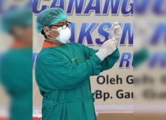 Vaksinator menyiapkan suntikan vaksin kepada salah satu penerima di RSUD Tugurejo