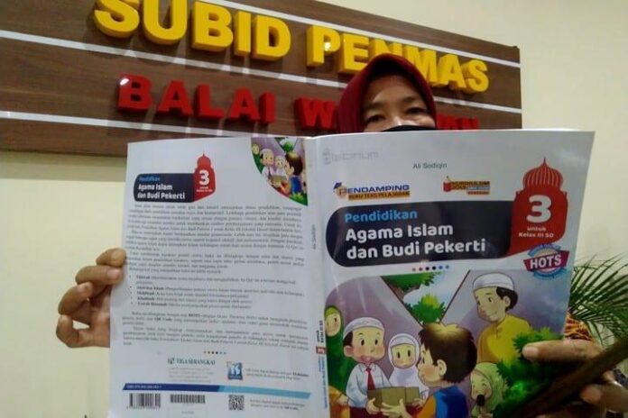 Perwakilan dari Forum Wali Murid Jateng menunjukkan buku pelajaran yang berisi ujaran kebencian, Senin (15/2).