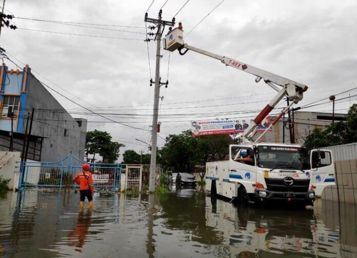 Petugas PLN melakukan pemulihan jaringan listrik di permukiman warga yang terdampak karena banjir