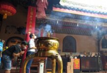Dua orang umat Tri Dharma tengah melakukan ritual doa di Kelenteng Tay Kak Sie Semarang.