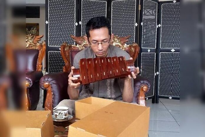 Sastrawan Lampung Arman Az sedang memegang gamolan pekhing atau cetik