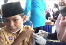 Seorang siswa mengikuti kegiatan vaksinasi