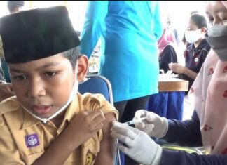 Seorang siswa mengikuti kegiatan vaksinasi