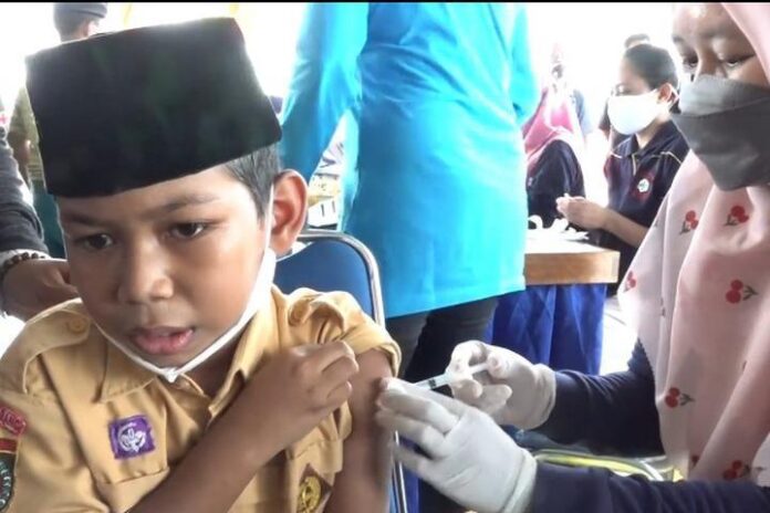 Seorang siswa mengikuti kegiatan vaksinasi