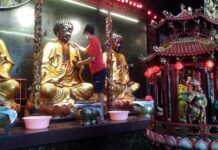 Membersihkan arca di Kelenteng Tay Kak Sie