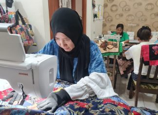 Lyna Windiarti bersama pekerja sedang menyelesaikan pesanan kain perca jadi produk olahan.