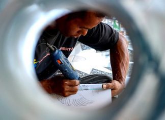 Seorang pelaku UMKM sedang menyelesaikan produk buatannya.