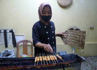 Pekerja sedang membakar sate ambal