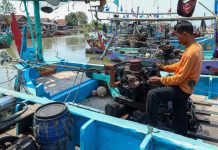 Nelayan memperbaiki jaring