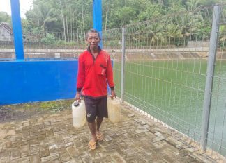 Warga mengambil air embung