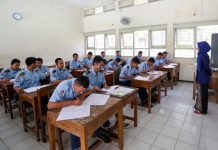 Guru sedang mengajar siswa di kelas.