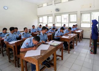 Guru sedang mengajar siswa di kelas.